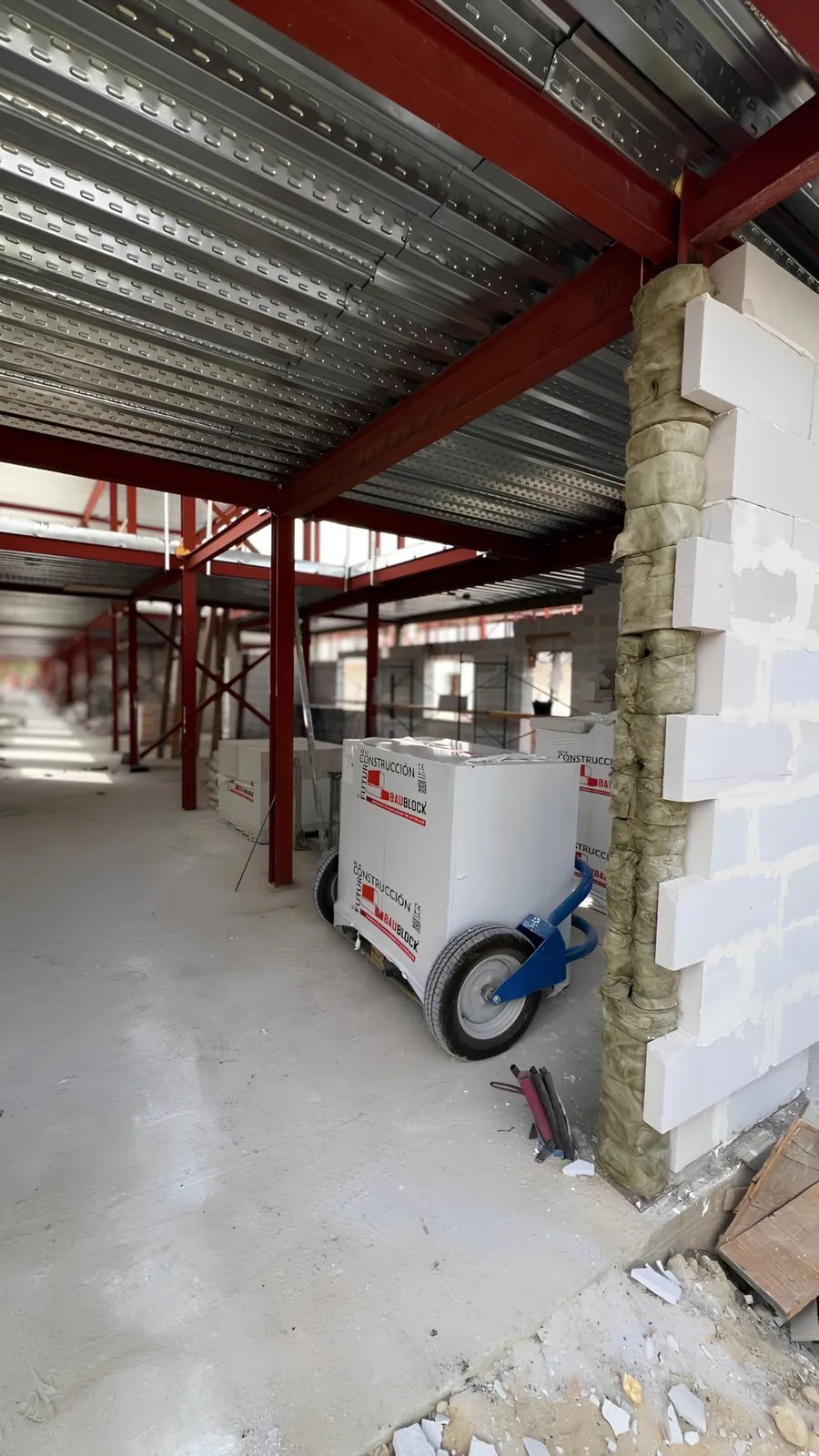 Materiais BAUBLOCK posicionados numa obra com estrutura metálica.