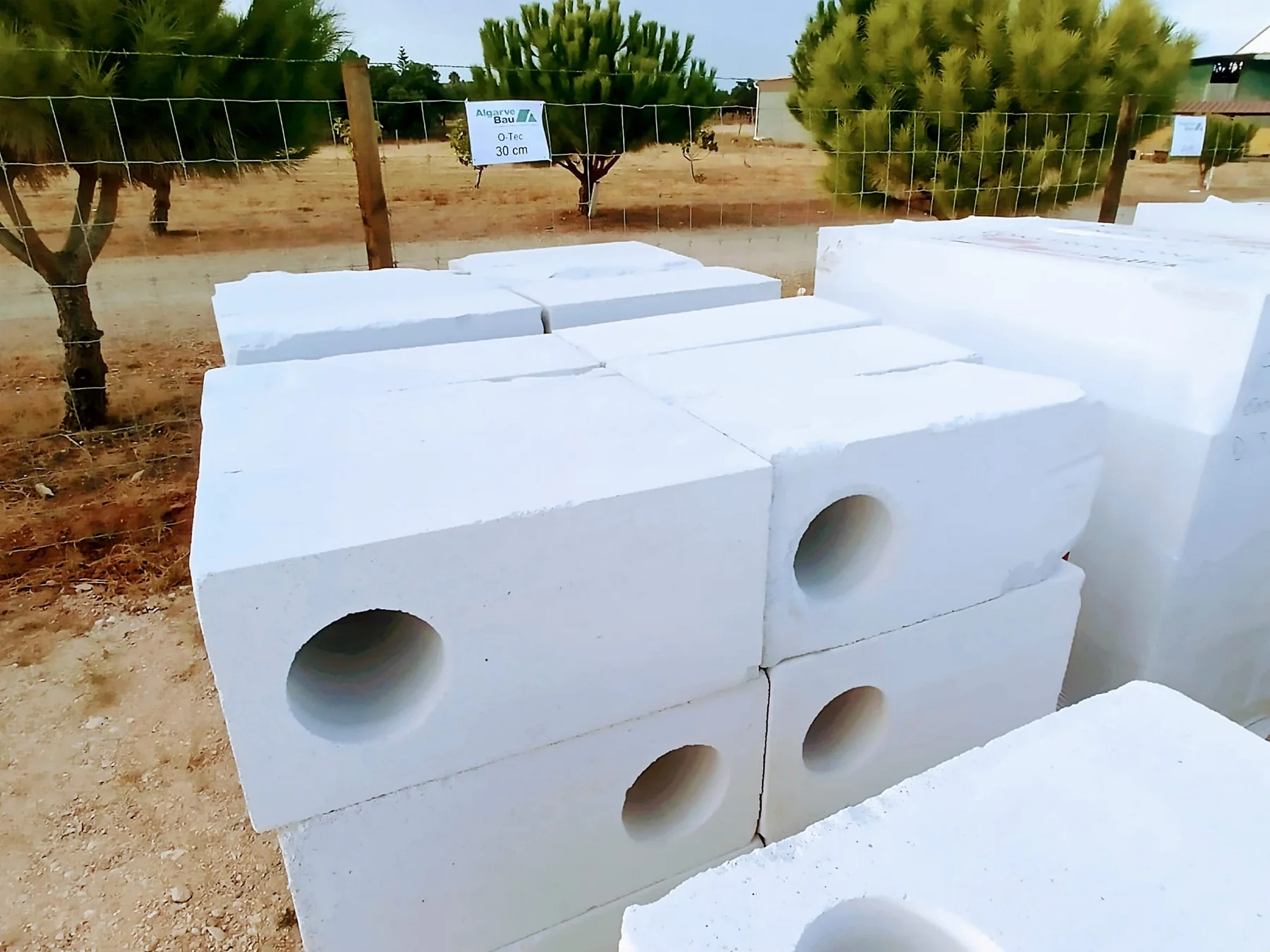Blocos BAUBLOCK O-TEC de 30 cm com núcleos circulares visíveis no stock atual no Algarve.